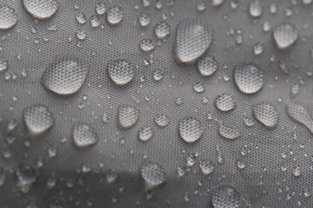 Water droplets beading on water-repellent (DWR) fabric surface