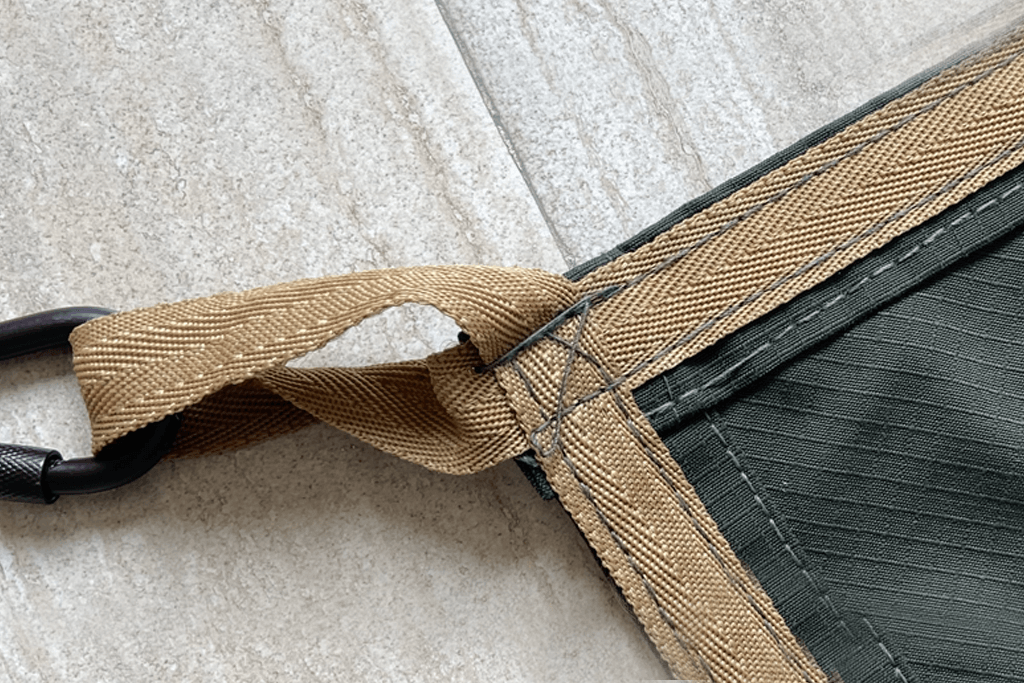 Close-up of heavy-duty tarpaulin fabric with webbing and eyelet
